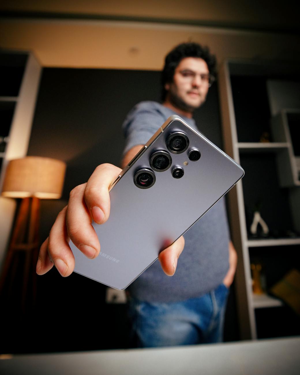 man presenting smartphone in a modern interior