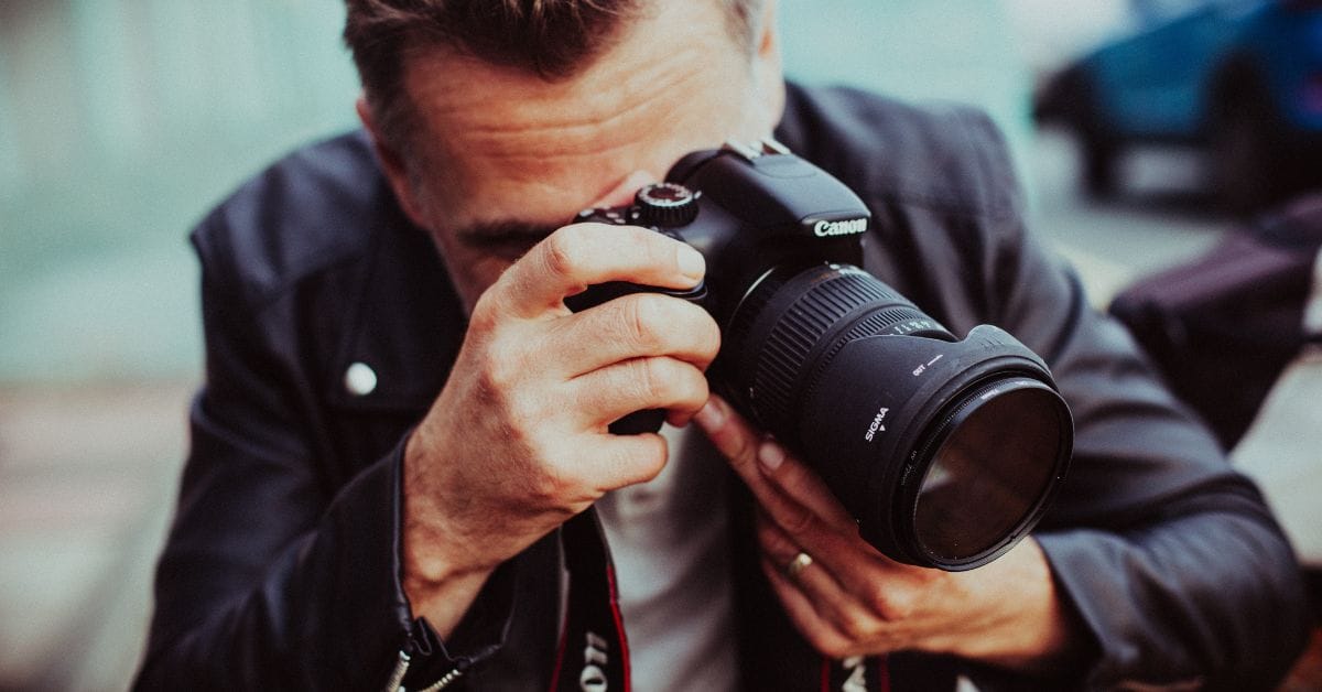 Mann fotografiert mit einer Canon Spiegelreflexkamera mit Sigma-Objektiv.